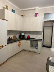 敖德萨Елисаветинская 15的厨房配有白色橱柜和黑色台面
