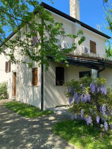 罗索利纳Holiday Home Giaron的白色房子前面有紫色的花