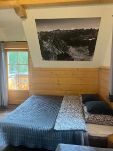 希切玛尔Góralski Domek Sucha Woda的卧室配有一张床,墙上挂有绘画作品