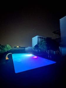 米多恩Résidence Jlidi的游泳池在晚上点亮,灯光蓝色