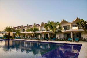 圣约翰斯Royalton CHIC Antigua All-Inclusive Resort - Adults Only的一个带椅子和遮阳伞的游泳池的度假酒店