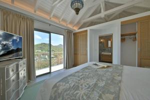 Saint BarthelemyVilla Vogue 5 Bedroom Villa的一间卧室设有一张大床和一个大窗户