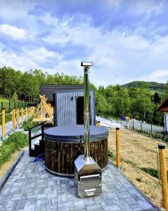 科尔别卢夫Chaty pod Pilskiem - sauna i jacuzzi w cenie - Krzyżówki - Korbielów的一座建筑前的木桶,上面有喷泉