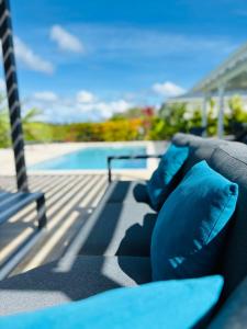 圣吕斯Villa Diamond的游泳池畔的沙发配有蓝色枕头