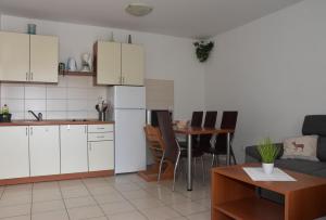 奇茲希Apartmani Andrea的厨房配有白色橱柜和桌椅