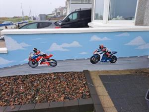 斯图尔特港NUMBER 5 Portrush Road, Portstewart的两个人在街上骑摩托车
