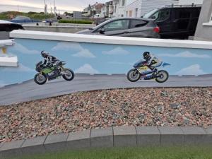 斯图尔特港NUMBER 5 Portrush Road, Portstewart的两个人在路上骑摩托车