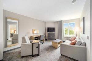 奥卡拉Candlewood Suites - Ocala I-75, an IHG Hotel的客厅配有沙发、椅子和书桌