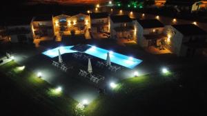 Petrina Bolosis的享有房子空中景色,晚上设有游泳池