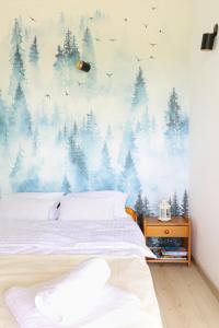 克拉科夫Strumienna Apartament的卧室配有一张壁挂森林壁画的床