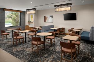 丹佛丹佛樱桃溪凯悦广场酒店的一间设有桌椅和平面电视的等候室