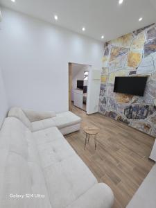 Novi BeogradIDILA SPA的客厅配有白色沙发和电视