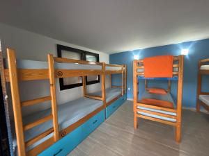 奥赫里德Blue Orange Lake Hostel的带三张双层床和椅子的房间