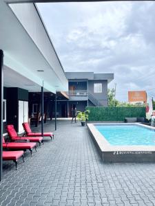 帕拉马里博Pavema Apartments的一个带红色椅子的庭院和一个游泳池