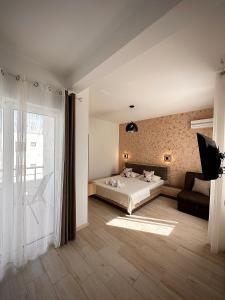 乌尔齐尼Apartmens Xhenis Lux的一间卧室配有一张床、一张沙发和一个窗口