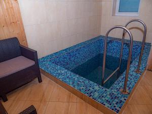 德拉格布拉特Оаза的浴室内设有一个蓝色瓷砖的游泳池