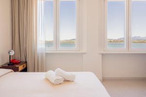奥尔比亚狄帕兰酒店的卧室配有带窗户的床上的2条毛巾