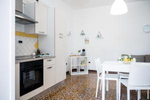 维耶特里Terrazza Mediterranea的厨房配有白色橱柜、桌子和白色椅子