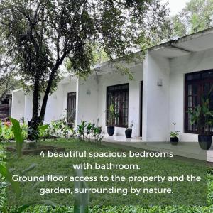 锡吉里亚Hotel Bird Paradise的美丽的宽敞卧室,设有浴室,花园四周环绕着大自然