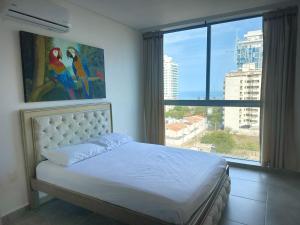 圣玛尔塔Salguero Suites - Playa Salguero - By INMOBILIARIA VS的一间卧室设有一张床和一个大窗户