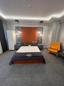 伊斯坦布尔Royal Suit Premium的一间卧室配有一张大床和一张橙色椅子