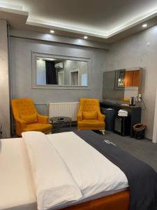 伊斯坦布尔Royal Suit Premium的一间卧室配有两把椅子、一张床和一张书桌