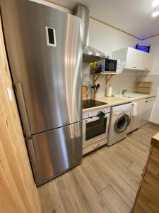 维拉尔-德朗Petit cocon comme a la maison的厨房配有不锈钢冰箱和洗碗机