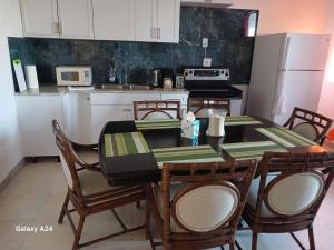 Wheeland SettlementNew condo with sea view unit 2的一间带桌椅的厨房和一间带白色橱柜的厨房