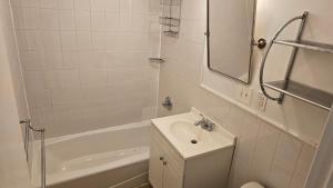 纽约Incentra Village Hotel的白色的浴室设有水槽和浴缸。