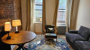 纽约Incentra Village Hotel的客厅配有沙发和桌子