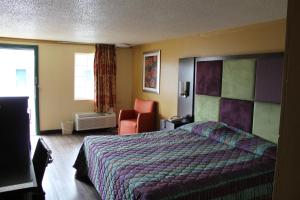 纳什维尔Executive Inn & Suites的配有一张床和一把椅子的酒店客房