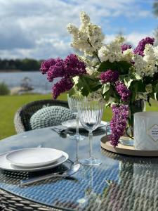 MikorzynBoskata Spa & Wellness Resort Ślesin的一张带紫色和白色花瓶的桌子