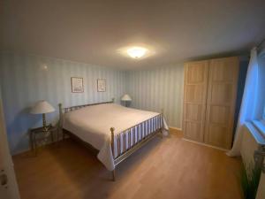 哈尔姆斯塔德Tylösand guesthouse 300m from ocean & golf course的一间卧室配有一张床和一盏灯,铺有木地板