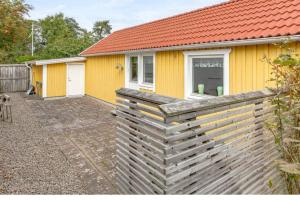 哈尔姆斯塔德Tylösand guesthouse 300m from ocean & golf course的前面有栅栏的黄色房子