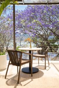 巴耶德布拉沃埃尔桑图阿里奥度假Spa酒店的鲜花盛开的庭院里的桌椅