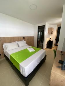 卡利Caliview Apartahotel的一间卧室配有一张带绿毯的大床