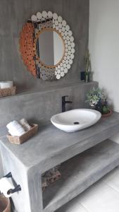 特科早特拉Casa Xahá的浴室设有水槽和镜子,位于柜台上