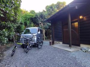 大岛Oshima-machi - House - Vacation STAY 51703v的两辆自行车停在一辆面包车旁边,旁边是一座建筑