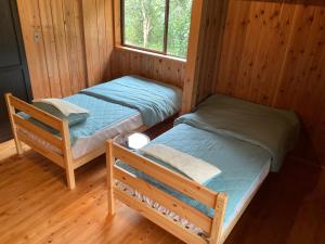 大岛Oshima-machi - House - Vacation STAY 51703v的小屋内的两张床,设有窗户