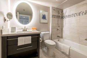 檀香山Aston Waikiki Beach Tower的浴室配有盥洗盆、卫生间和浴缸。