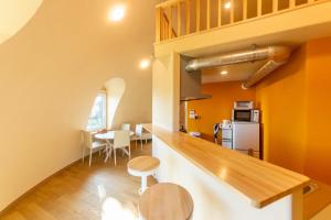 南房总市Cam Cam Dome House & SAUNA (Toyooka Beach) - Vacation STAY 66777v的一间厨房和用餐室,拥有橙色的墙壁和木地板