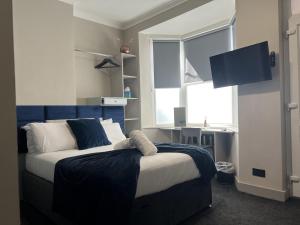 谢菲尔德Sleeps up to 8 A 4-Bed House all with en-suites的一间卧室配有一张带蓝色床头板的床和窗户