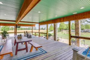 Hornersville Vacation Rental with Private Pond!的一个带木桌和长凳的大甲板