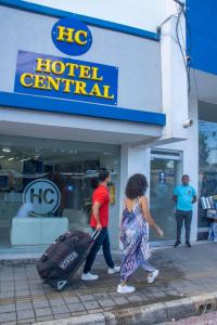 辛塞莱霍Hotel Central的几个有行李的人在酒店航站楼前走