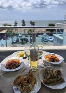 圣金Sea view Shengjin的餐桌,带食物盘和一瓶葡萄酒