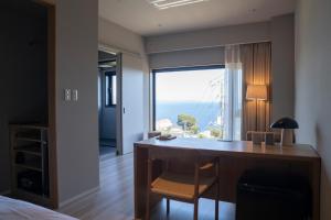 真鹤町HOTEL FARO manazuru - Vacation STAY 56476v的一间卧室设有一张书桌,享有海景