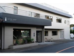 真鹤町HOTEL FARO manazuru - Vacation STAY 56476v的前面有长凳的白色建筑