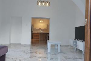 凯里尼亚Girne, Lapta'da Deniz ve Dağ Manzaralı的客厅配有桌子和电视