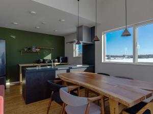 带广Buena Vista Tokachi - Vacation STAY 47319v的厨房配有木桌和大窗户。