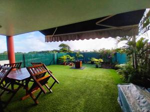 MahinaTAHITI - Amoe Condo的草坪上配有两把椅子和一张桌子的庭院